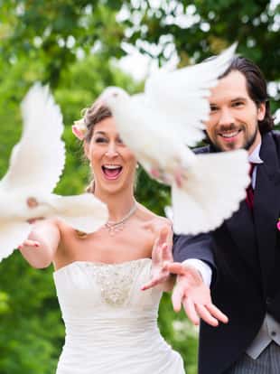 Bridal pair with flying white doves at wedding