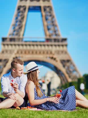 Romantic couple having picnic near the Eiffel tower in Paris, France