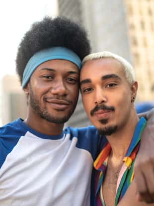 Male couple embracing during LGBTQI parade